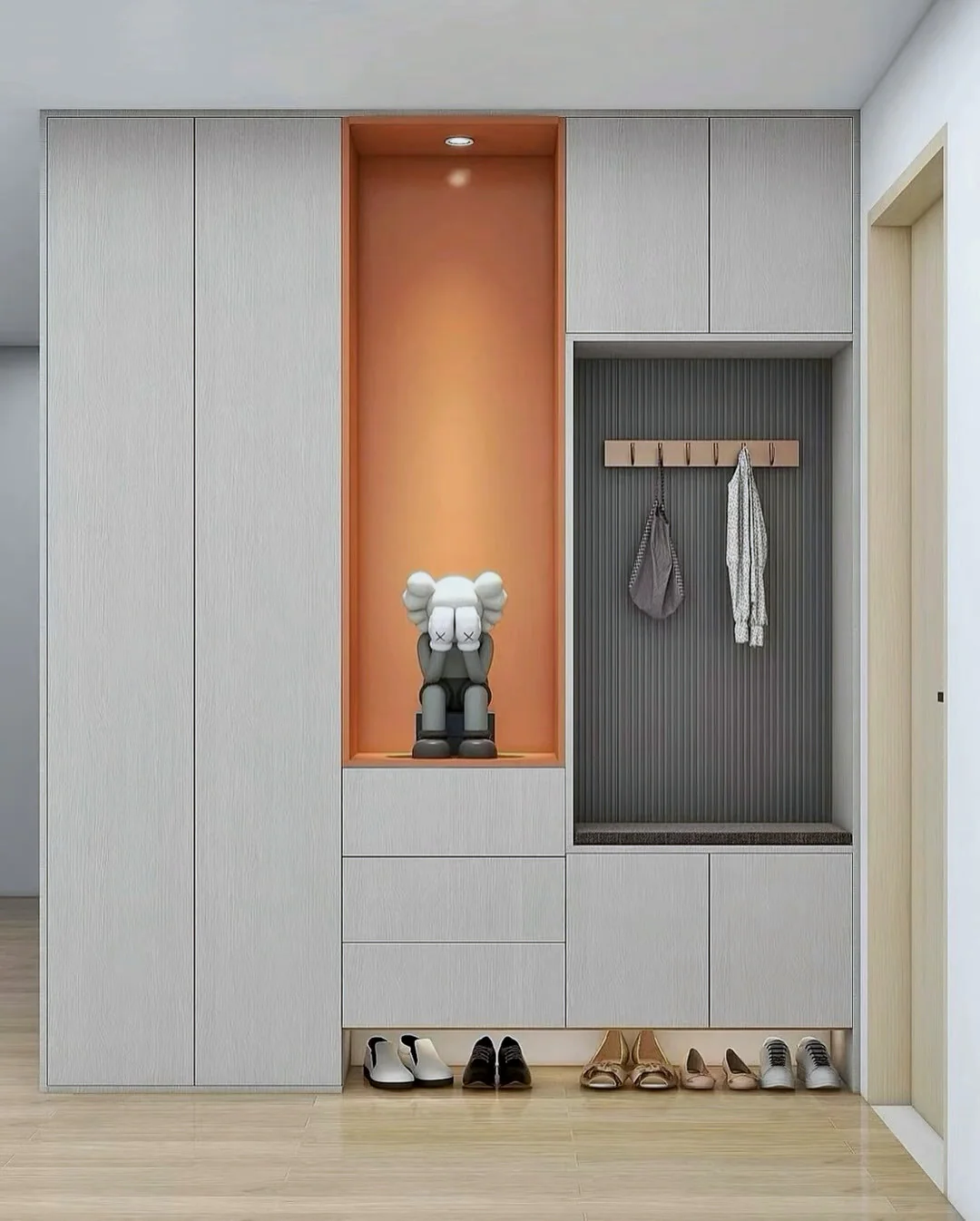 Light wood entry cabinet with an orange display niche, coat hooks, drawers and shoe storage