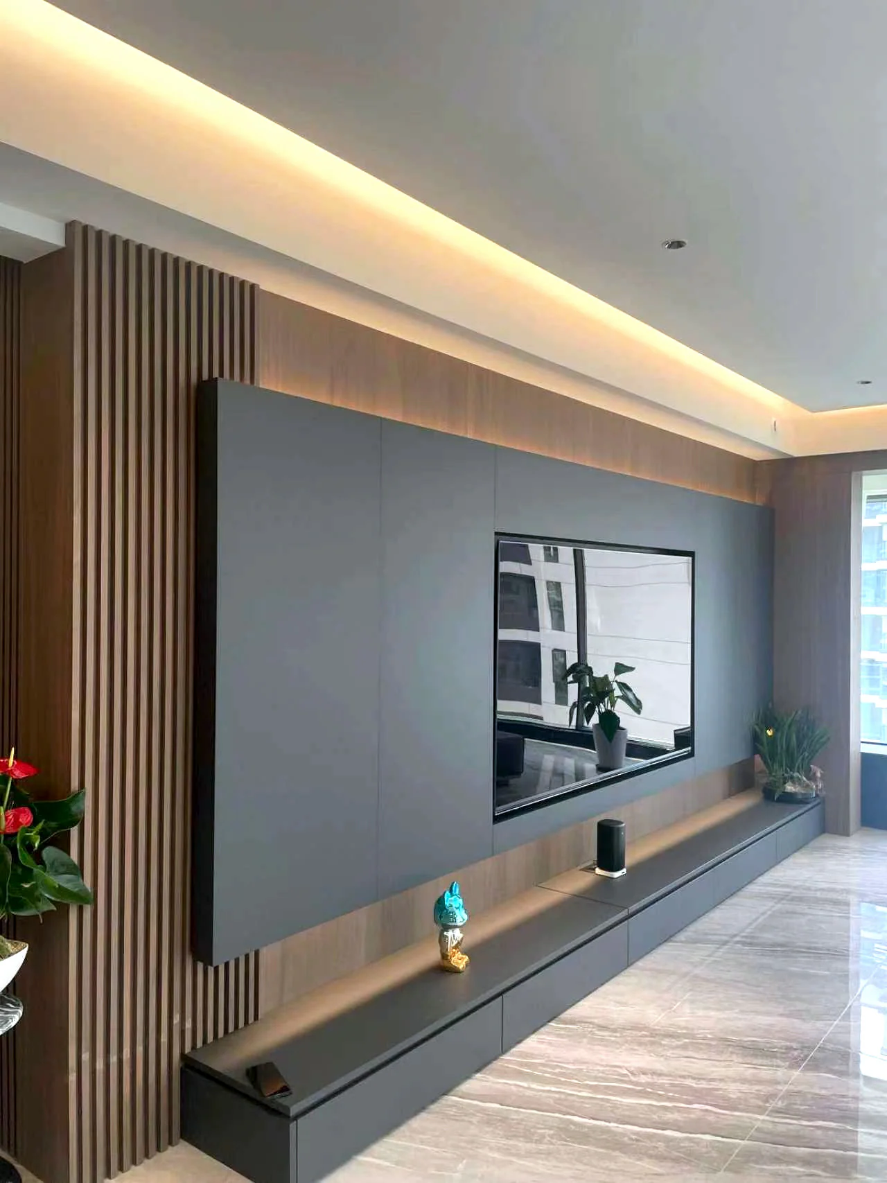 Dark television wall with vertical wood slats, a floating low cabinet and concealed side storage
